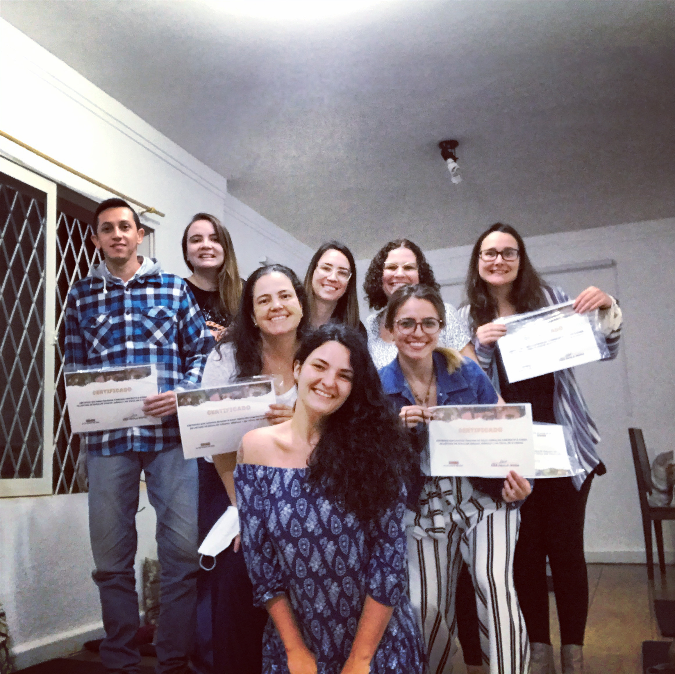 homem e mulheres com certificados acompanhados da instrutora